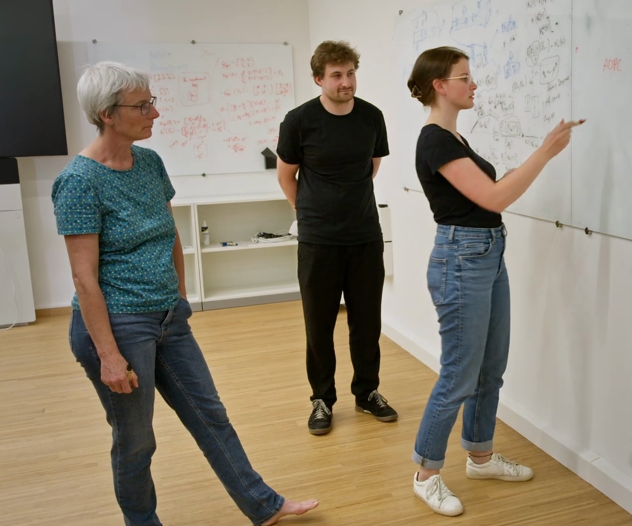Group members discussing mathematics at a whiteboard