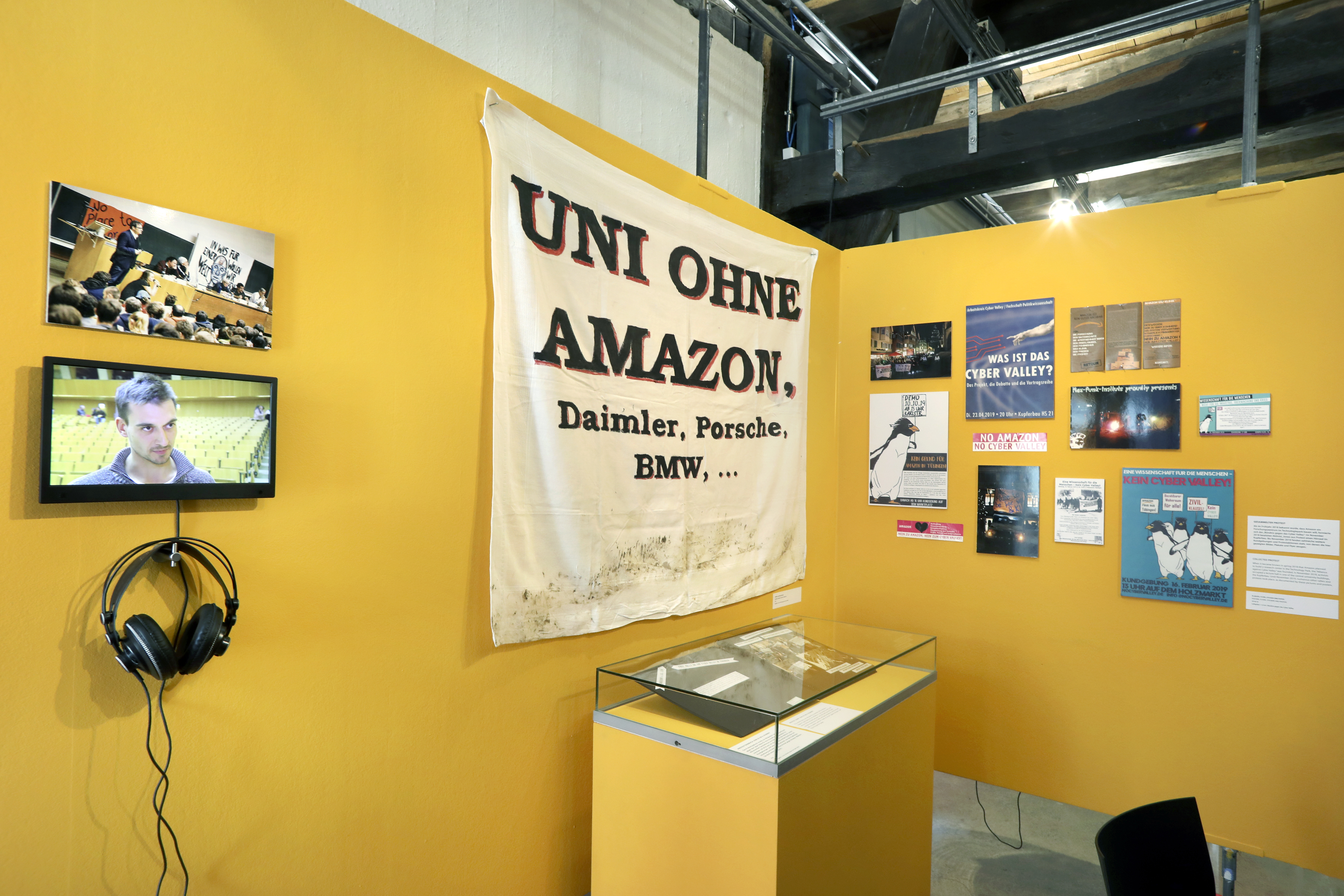 Yellow exhibition displays documenting the public debate about AI research and industry funding